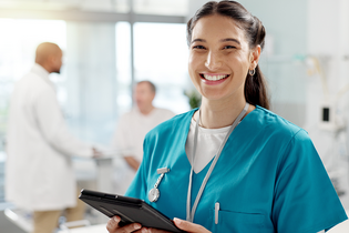 Lächelnde Pflegekraft mit Tablet in den Händen. 