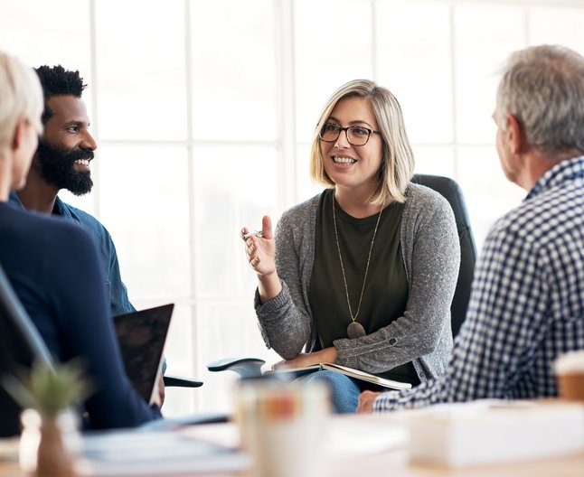 4 Personen halten eine Besprechung an einem Tisch ab