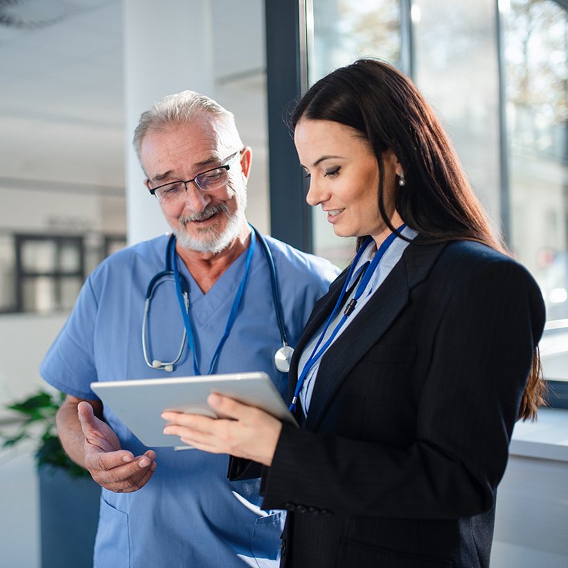 Frau mit Tablet in Beratungssituation mit Pfleger