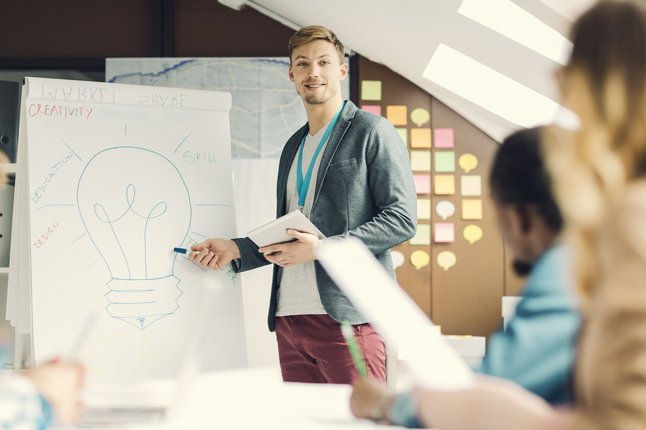 Mann hält Präsentation mit Flipchart vor Publikum