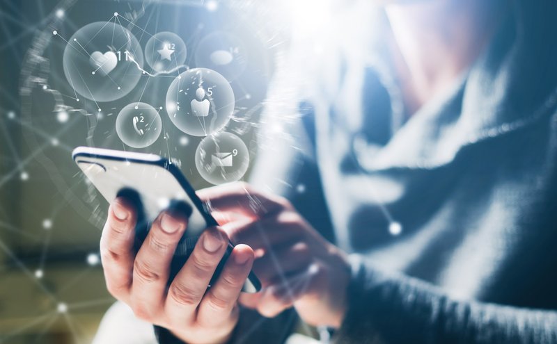 Person hält Smartphone in der Hand und tippt